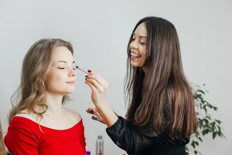 Master does a beautiful blonde makeup in a beauty salon Stock Photos