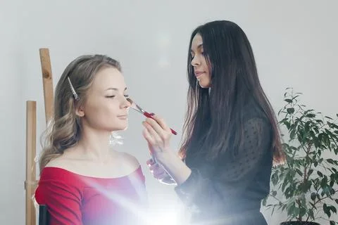 Master does a beautiful blonde makeup in a beauty salon Stock Photos