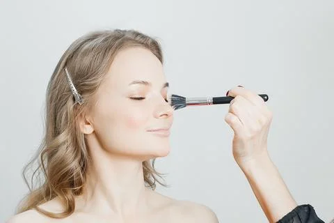 Master does a beautiful blonde makeup in a beauty salon Stock Photos