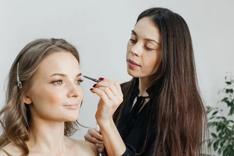 Master does a beautiful blonde makeup in a beauty salon Stock Photos