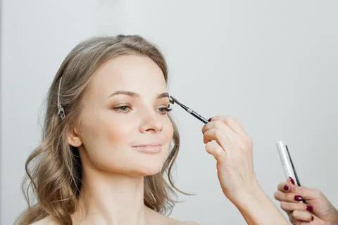 Master does a beautiful blonde makeup in a beauty salon Stock Photos