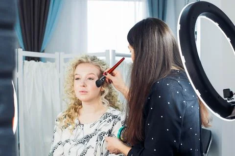 Master does a beautiful blonde makeup in a beauty salon Stock Photos