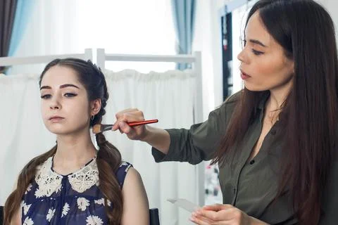 Master does a beautiful blonde makeup in a beauty salon Stock Photos