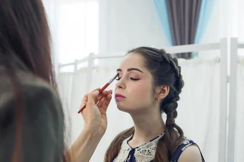 Master does a beautiful blonde makeup in a beauty salon Stock Photos