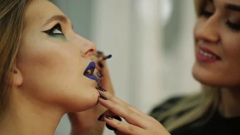The master does the make-up of a beautiful young girl Stock Footage 73768945