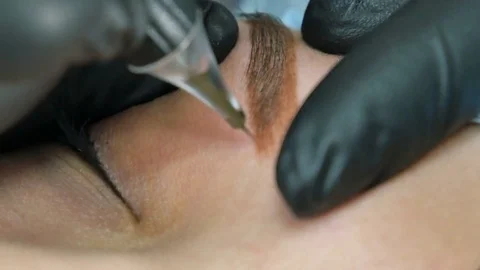 Master does tattoo of eyebrows close-up Stock Footage 76660858