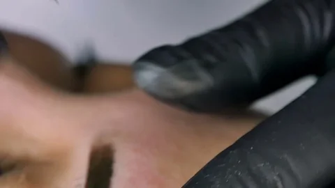 Master does tattoo of eyebrows close-up Stock Footage 76668010