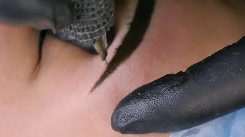 Master does tattoo of eyebrows close-up Stock Footage 76668546