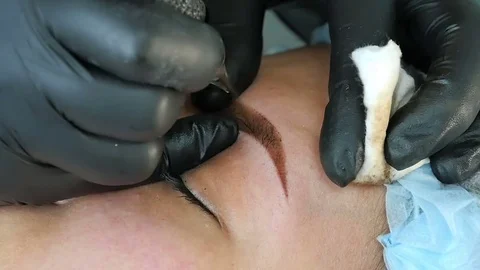 Master does tattoo of eyebrows close-up Vídeo Stock 76670173