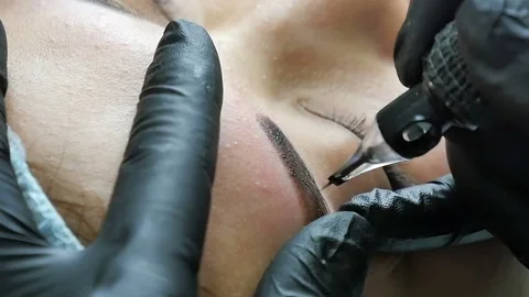 Master does tattoo of eyebrows close-up Stock Footage 76673335