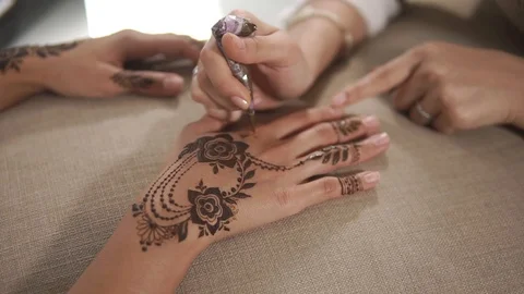 Master is doing trendy henna pattern on skin of customer woman in beauty salon Stock Footage 90455274
