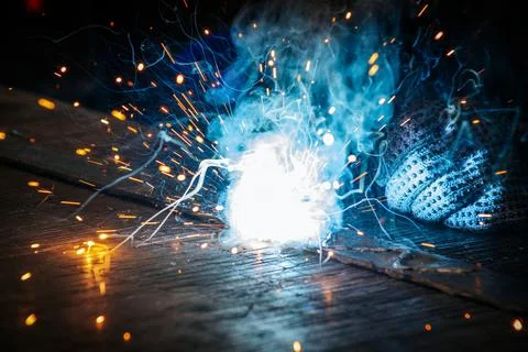 Master is doing welding at his workplace in the workshop, while sparks are .. Stock Photos