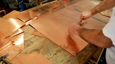 The master draws a circle on a sheet of copper Stock Footage 124428185