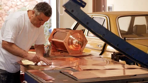 The master draws the shape of the product on a copper sheet using a ruler Stock Footage 124464483