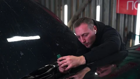 Master drills a chipped windshield with a drill. Slow Motion. Stock Footage 232040930