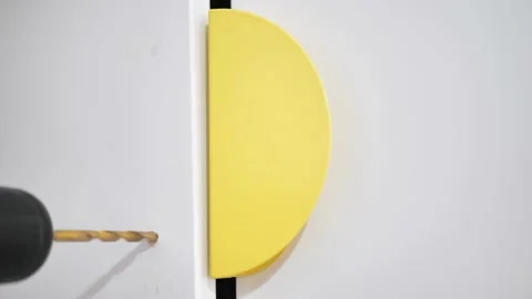 The master drills a hole in the wall with a drill, inserts a screw, twists it Video stock 226626094