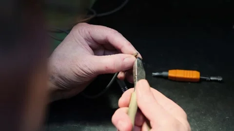 Master electrician removes insulation from copper wires with a special tool Stock Footage 302353971