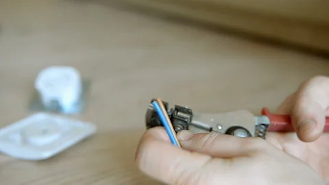 The master electrician removes the insulation from the wire Stock Footage 101320571