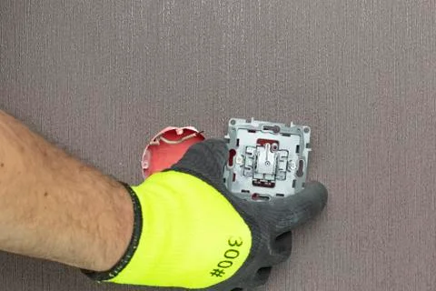 The master electrician sets the switch. Close-up. The room is colored. The sw Stock Photos