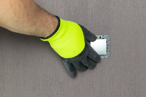 The master electrician sets the switch. Close-up. The room is colored. The sw Stock Photos