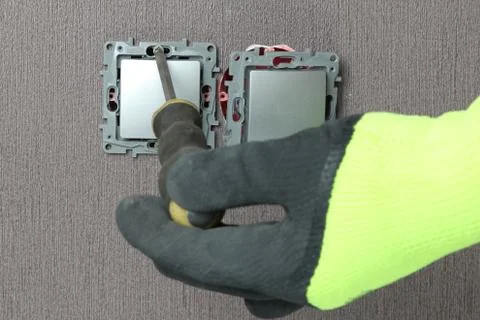 The master electrician sets the switch. Close-up. The room is colored. The sw Stock Photos