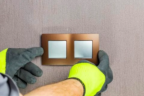 The master electrician sets the switch. Close-up. The room is colored. The sw Stock Photos