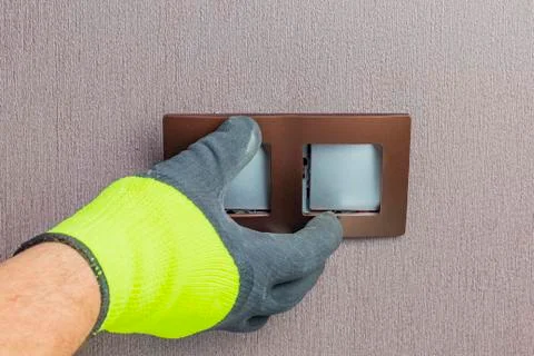 The master electrician sets the switch. Close-up. The room is colored. The sw 스톡 사진