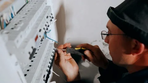 The Master Electrician strips the insulation from the cable for connection to Stock Footage 151953379