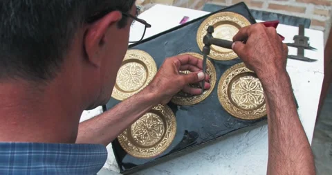 A master embosser creates a pattern on a copper plate using ancient technologies Stock Footage 277873323