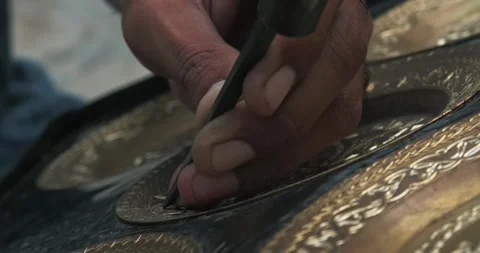 A master embosser creates a pattern on a copper plate using ancient technologies Stock Footage 277873356