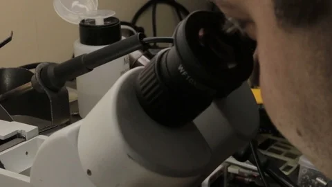 The master examines a printed circuit board under an electron microscope. Stock Footage 101295872