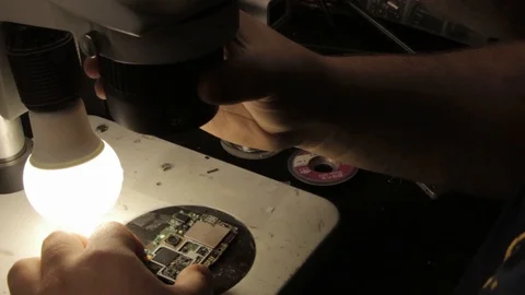 The master examines a printed circuit board under an electron microscope Stock Footage 101295876