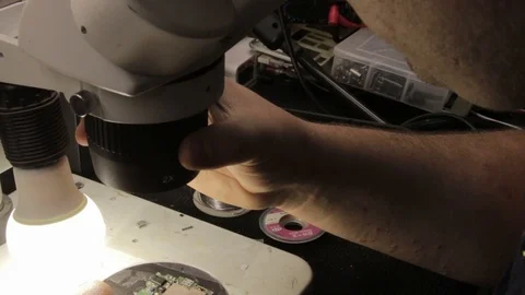 The master examines a printed circuit board under an electron microscope Stock Footage 101295886