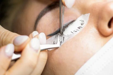 The master extends eyelashes. Stock Photos