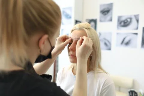 The master of eyebrow design works with the client Stock-Fotos