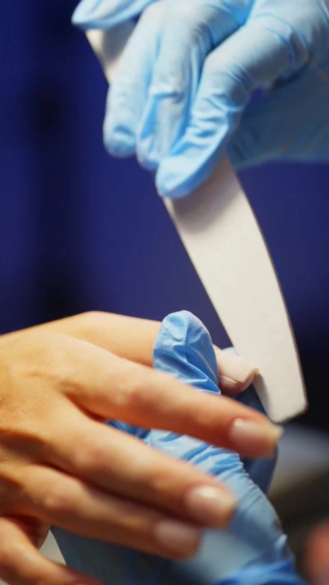 The master files the client's nail plate with a nail file. Stock Footage 325569892