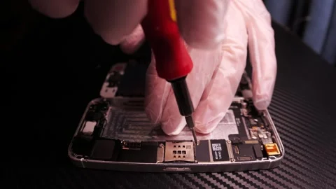 The master fixes the phone, using tools. Close up hands, black table, diy Stock Footage 261410102