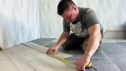 Master of floor installation and the process of laying laminate on the floor. Vídeo Stock 249312152