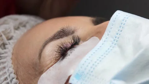 The master gently pours special eyelash glue into a saucer that will be used in Stock Footage 155156255