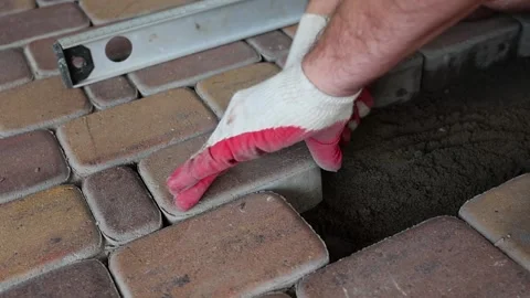 Master in gloves, process of laying paving stones, sealing with a mallet. Stock Footage 202201736