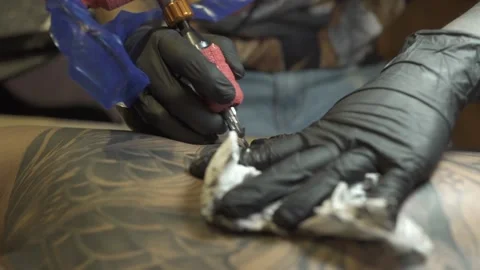 Master in gloves wipes ink from visitor back with napkin Video stock 145571179