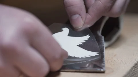 Master glue on the surface of the axe sticker Stock Footage 129695444