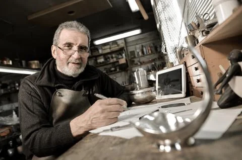 Master goldsmith working with silver-Creative drawing of a silver object Stock-Fotos