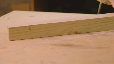 The master grinds the boards cut with a circular saw with a grinding machine Video stock 182225973