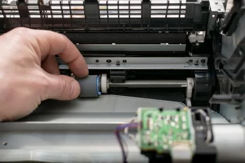 The master hand changes the rubber grip roller in the printer Stock Photos