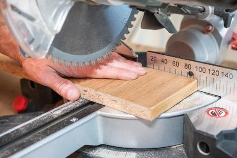 Master hand is dangerously close to the blade disc of a circular saw while cu Stock Photos