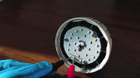 Master hands fixing led lamp by multimeter probes Stock Footage 220844561
