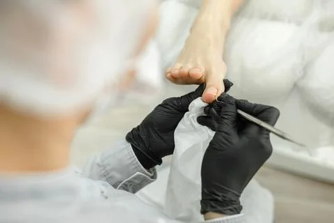 Master hardware pedicure during operation. Nail processing and milling Stock Photos