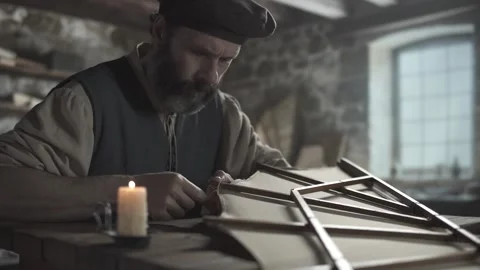 Master hemming fabric on an ornithopter wing at a timber table near a candle 스톡 동영상 338992121