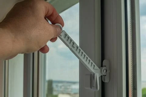 Master installed fixing limiter for opening a plastic window and checks its.. Stock Photos